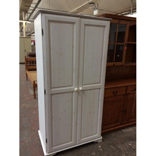 555 - A WHITE PAINTED PINE DOUBLE WARDROBE