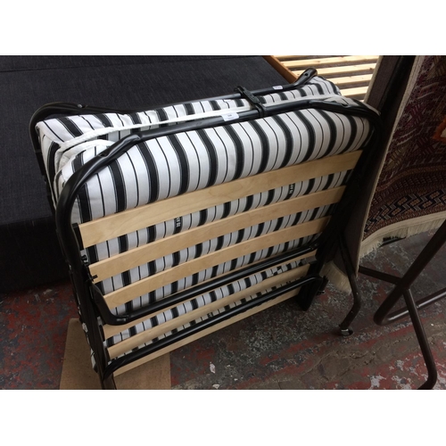 568 - A JAYBE FOLDING BED WITH BLACK AND WHITE STRIPED MATTRESS