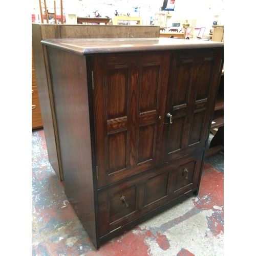 610 - AN OAK TV CABINET WITH TWO DOORS AND ONE DRAWER