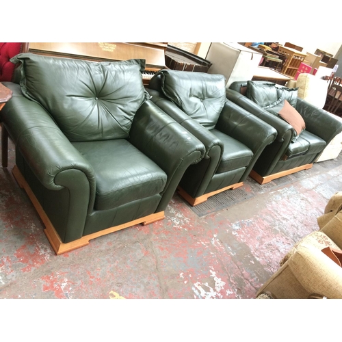 675 - A GREEN LEATHER TWO SEATER SOFA AND TWO MATCHING ARMCHAIRS