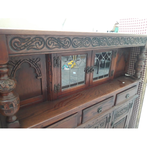 1119 - AN ANTIQUE STYLE TIGER OAK COURT CUPBOARD WITH THREE LOWER DOORS, THREE DRAWERS AND TWO UPPER GLAZED... 