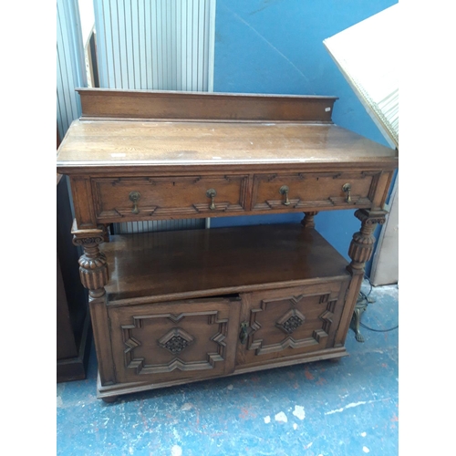 1124 - A GOOD QUALITY 20TH CENTURY CARVED OAK BUFFET WITH TWO LOWER DOORS, TWO UPPER DRAWERS WITH BRASS TEA... 