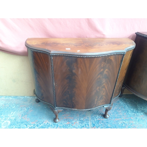 1153 - A FLAMED MAHOGANY SIDEBOARD WITH SERPENTINE TOP AND ONE CENTRE DOOR ON DOG PAD FEET