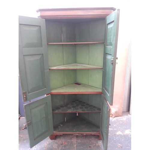 1125A - A GEORGIAN FLAMED MAHOGANY CORNER CUPBOARD WITH TWO LONG UPPER AND TWO SHORT LOWER DOORS WITH BRASS ... 