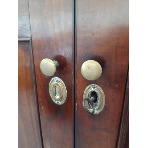 1125A - A GEORGIAN FLAMED MAHOGANY CORNER CUPBOARD WITH TWO LONG UPPER AND TWO SHORT LOWER DOORS WITH BRASS ... 