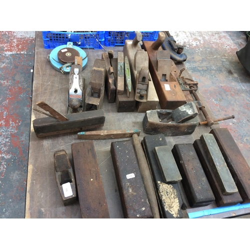 135 - A MIXED LOT TO INCLUDE VINTAGE WOOD BLOCK PLANES, OIL STONES, STANLEY WOOD PLANE AND HAND DRILL, BLA... 