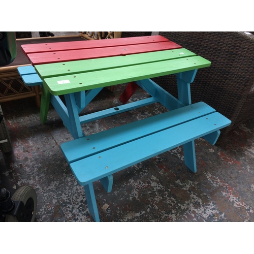 42 - A MULTI COLOURED CHILD'S GARDEN TABLE AND BENCH SET