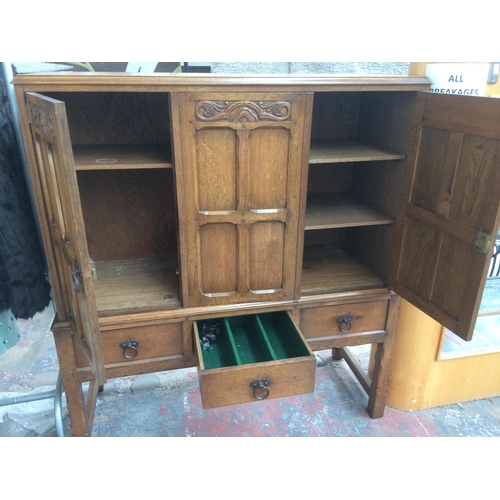 237 - A GOOD QUALITY GOLDEN OAK CABINET WITH THREE DOORS AND THREE DRAWERS SET UPON A STRETCHER BASE (MEAS... 