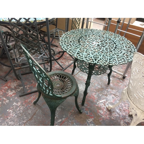 25 - TWO ITEMS TO INCLUDE A CIRCULAR CAST IRON ORNATE PATIO TABLE AND CHAIR