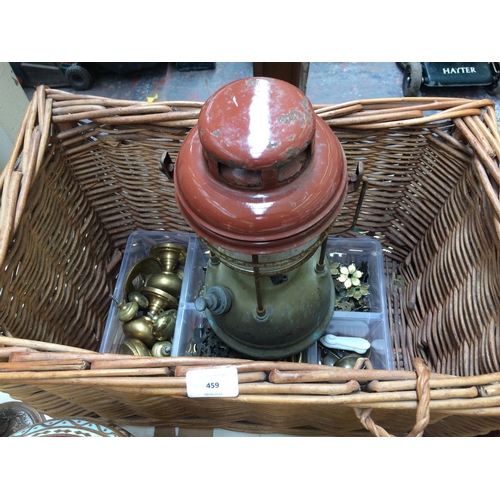 459 - A WICKER BASKET CONTAINING BRASS DOOR FURNITURE AND A VINTAGE STORM LANTERN