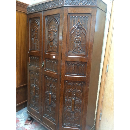 587 - A GOOD QUALITY CARVED OAK HALL ROBE WITH TWO DOORS (MEASURING 52