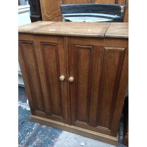 621 - A PINE TWO DOOR CABINET WITH HINGED LID