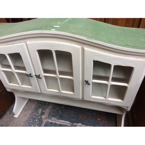 622 - A WHITE PAINTED DRESSER TOP WITH THREE GLAZED DOORS AND ONE LOWER SHELF