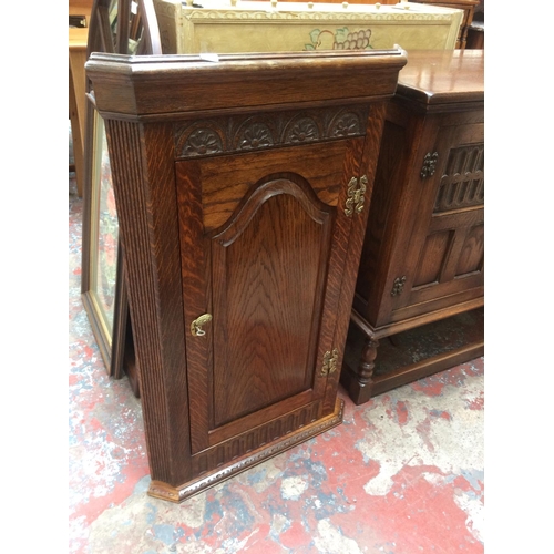 650 - AN OAK WALL HANGING CORNER CABINET WITH ONE DOOR AND THREE INNER SHELVES