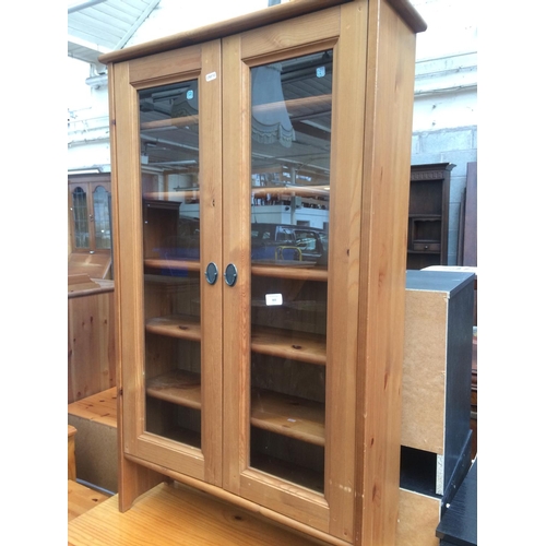 663 - A MODERN PINE FREE STANDING CABINET WITH TWO GLASS DOORS AND FIVE SHELVES