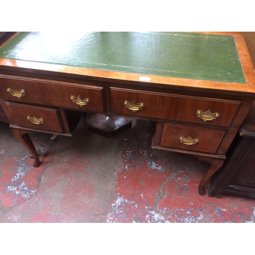 675 - A MAHOGANY GREEN LEATHER TOP DESK WITH TWO LONG DRAWERS AND TWO SHORT DRAWERS ON CABRIOLE SUPPORTS (... 