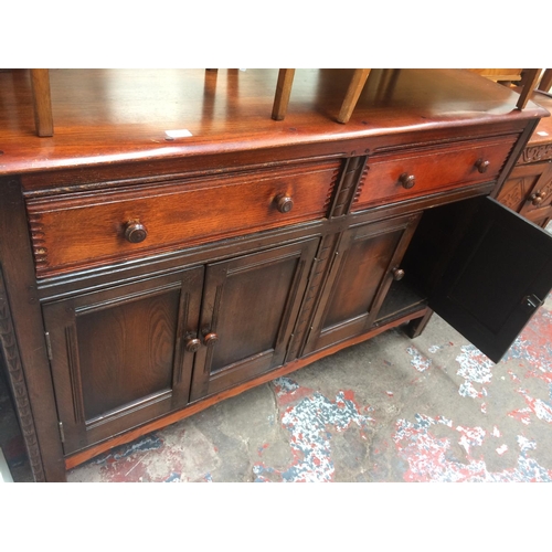 694 - AN OAK SIDEBOARD WITH FOUR DOORS AND TWO DRAWERS