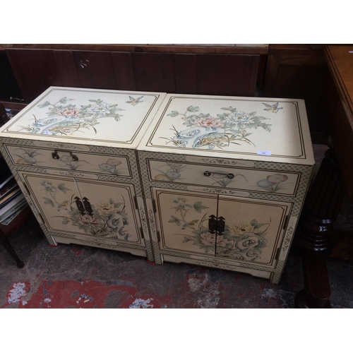 700 - A PAIR OF ORIENTAL FLORAL DESIGN CABINETS WITH TWO DOORS AND TWO DRAWERS IN EACH