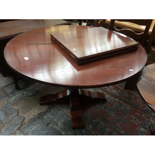 750 - A MAHOGANY EFFECT CENTRE PEDESTAL EXTENDING DINING TABLE WITH ONE EXTRA LEAF