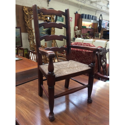 753 - A VINTAGE OAK FRAMED RUSH SEATED CHILD'S LADDER BACK CHAIR