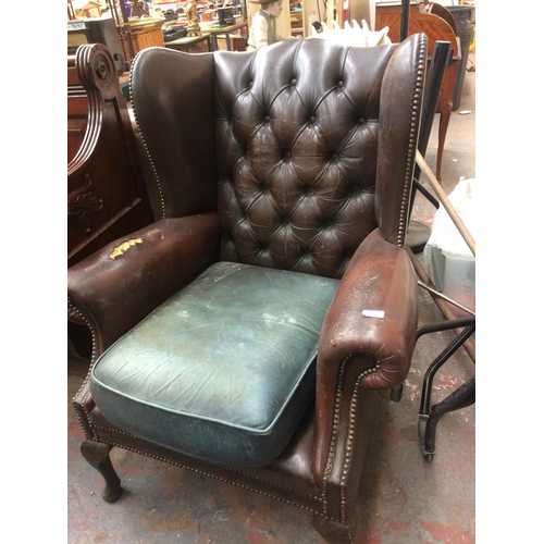 772 - A BROWN LEATHER CHESTERFIELD WINGBACK ARMCHAIR ON CABRIOLE SUPPORTS (IN NEED OF ATTENTION)