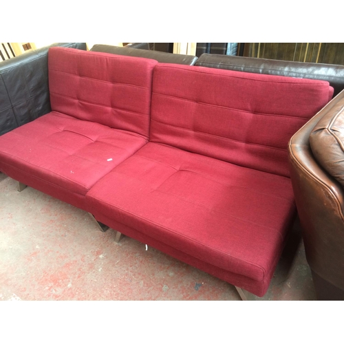 809 - A RED UPHOLSTERED COLLAPSIBLE TWO SEATER BED SOFA