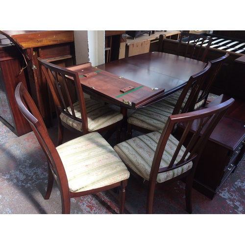 745A - A MAHOGANY TWIN PEDESTAL EXTENDING DINING TABLE WITH SIX MATCHING CHAIRS AND ONE EXTRA LEAF