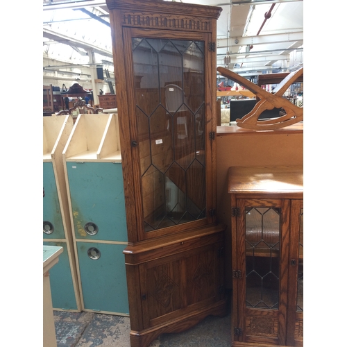 638 - A GOOD QUALITY JAYCEE OAK FREE STANDING CORNER CABINET WITH ONE UPPER LEADED GLASS DOOR, ONE LOWER D... 