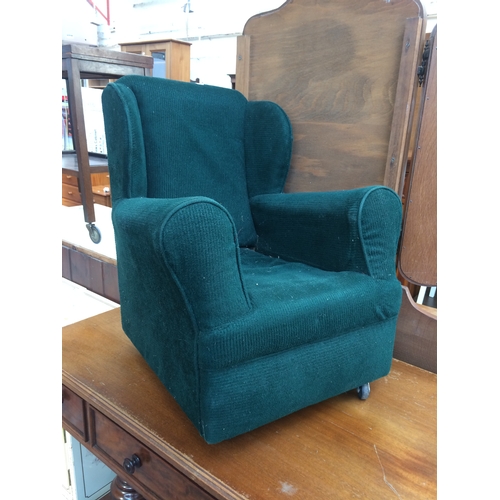 698 - A GOOD QUALITY SMALL CHILD'S GREEN UPHOLSTERED WINGBACK ARMCHAIR