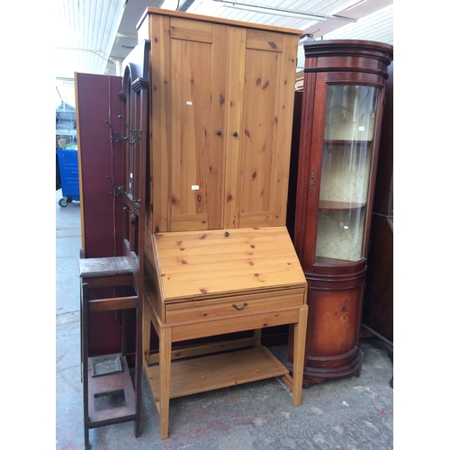 710 - A MODERN PINE BUREAU BOOKCASE WITH TWO UPPER DOORS, ONE DRAWER AND FALL FRONT