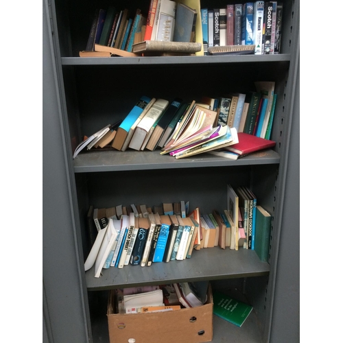 25 - A GREY METAL TWO DOOR OFFICE STORAGE CABINET CONTAINING A LARGE QUANTITY OF BOOKS