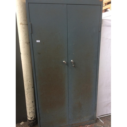 26 - A GREY METAL TWO DOOR OFFICE STORAGE CABINET CONTAINING A LARGE QUANTITY OF BOOKS