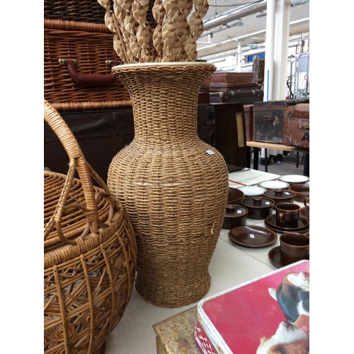 369 - AN ORNATE WICKER LIDDED BASKET AND A WICKER VASE WITH CONTENTS