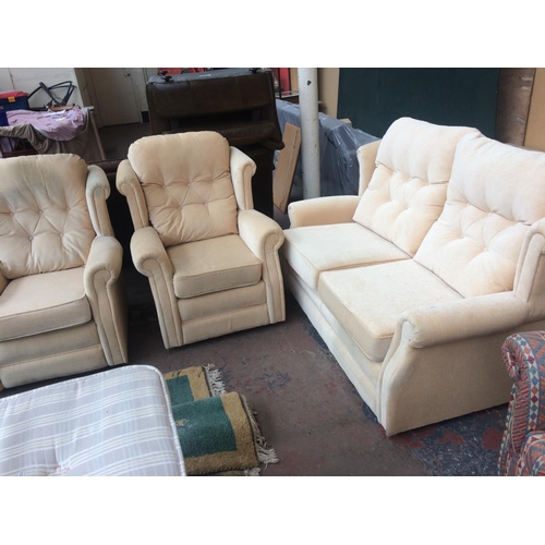 685 - A CREAM UPHOLSTERED TWO SEATER SOFA AND TWO MATCHING ARMCHAIRS