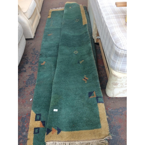 688 - A LARGE GREEN PATTERNED RUG