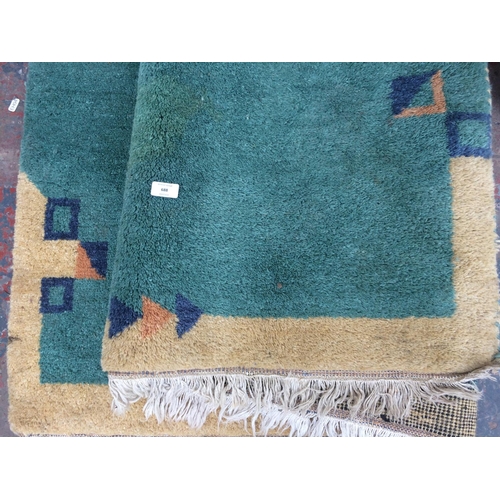 688 - A LARGE GREEN PATTERNED RUG