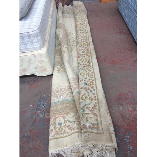 690 - A LARGE CREAM FLORAL PATTERNED RUG