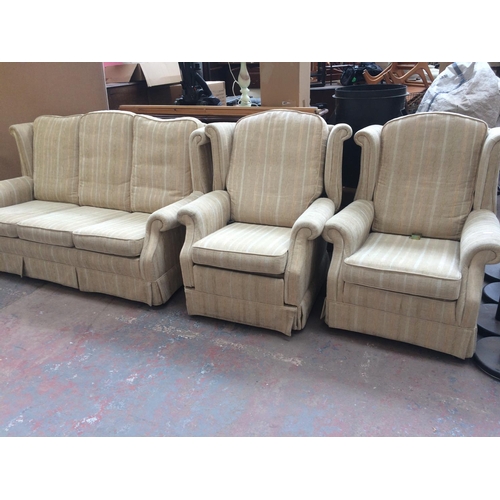 691 - A BEIGE REGENCY STRIPED TWO SEATER SOFA AND TWO MATCHING ARMCHAIRS INCLUDING ONE RECLINER