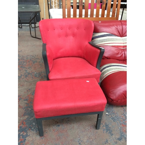 809A - A RED UPHOLSTERED ARMCHAIR AND FOOTSTOOL