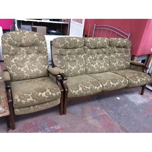 812 - A GREEN FLORAL UPHOLSTERED THREE SEATER SOFA AND MATCHING ARMCHAIR