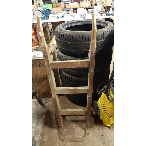 127 - A VINTAGE WOODEN TWO WHEELED SACK TRUCK WITH CAST IRON WHEELS