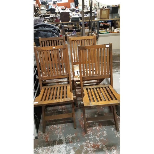 33 - FOUR TEAK WOOD FOLDING PATIO CHAIRS