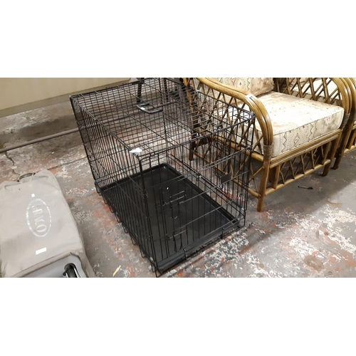 35 - A BLACK METAL DOG CAGE WITH PLASTIC BASE