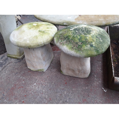 217 - TWO CAST STONE SADDLE STONES - MEASURING APPROX. HEIGHT 48CM