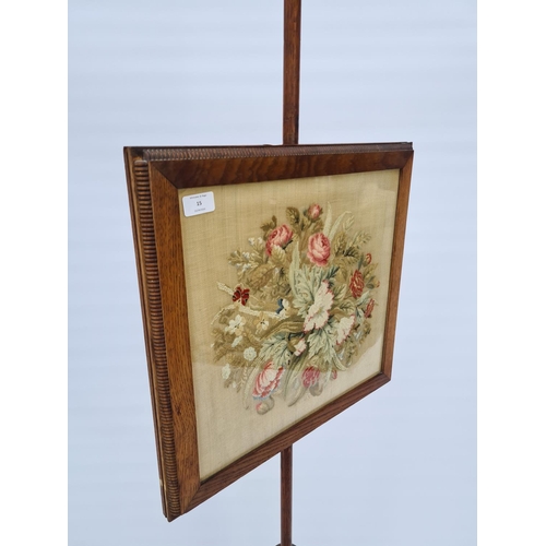 27 - A VICTORIAN OAK ADJUSTABLE FIRESCREEN WITH GLAZED FRONT HOLDING INNER FLORAL TAPESTRY ON BUN FEET - ... 