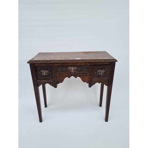 65 - A VICTORIAN HEAVILY CARVED OAK HALL TABLE WITH THREE DRAWERS EACH HAVING FOLIATE MASK DETAILING ON T... 