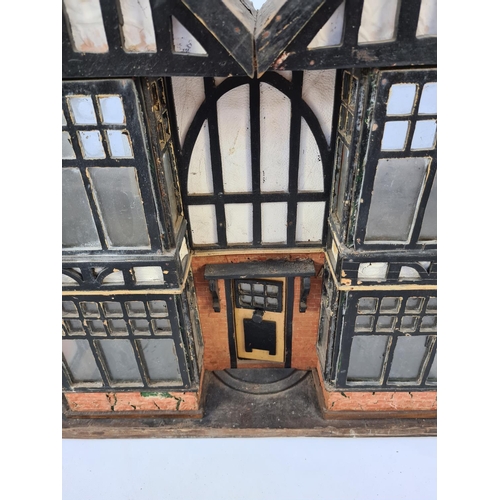 71 - AN EARLY TO MID 20TH CENTURY SCRATCH BUILT WOODEN TUDOR DOLL'S HOUSE WITH FOUR ROOMS, TWO HALLWAYS A... 