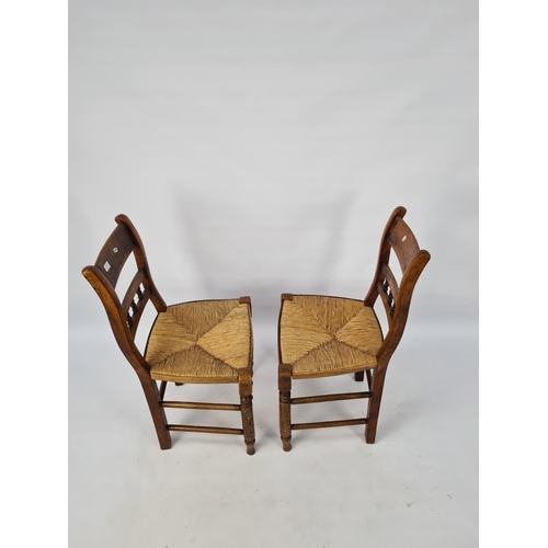 68 - A PAIR OF VICTORIAN ELM DINING CHAIRS WITH TURNED LOWER STRETCHERS AND RUSH SEATS