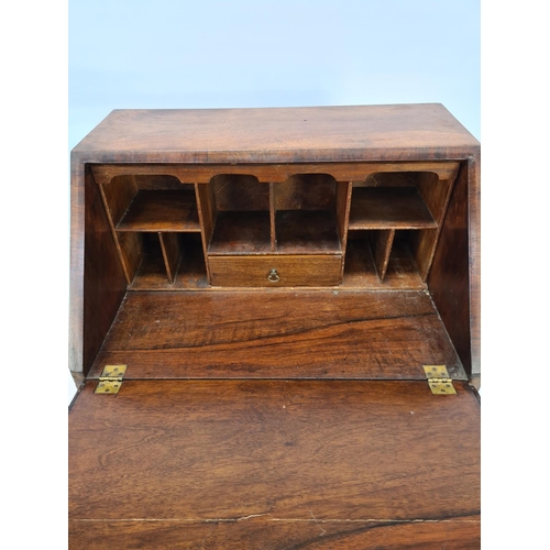 29 - A GEORGIAN WALNUT BUREAU WITH FOUR DRAWERS, BRASS HANDLES, BRASS ESCUTCHEONS AND BRACKET FEET - MEAS... 