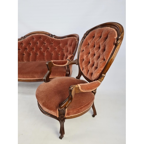 45 - A VICTORIAN CARVED MAHOGANY TWO PIECE PARLOUR SUITE COMPRISING PINK UPHOLSTERED BUTTON BACKED SOFA O... 